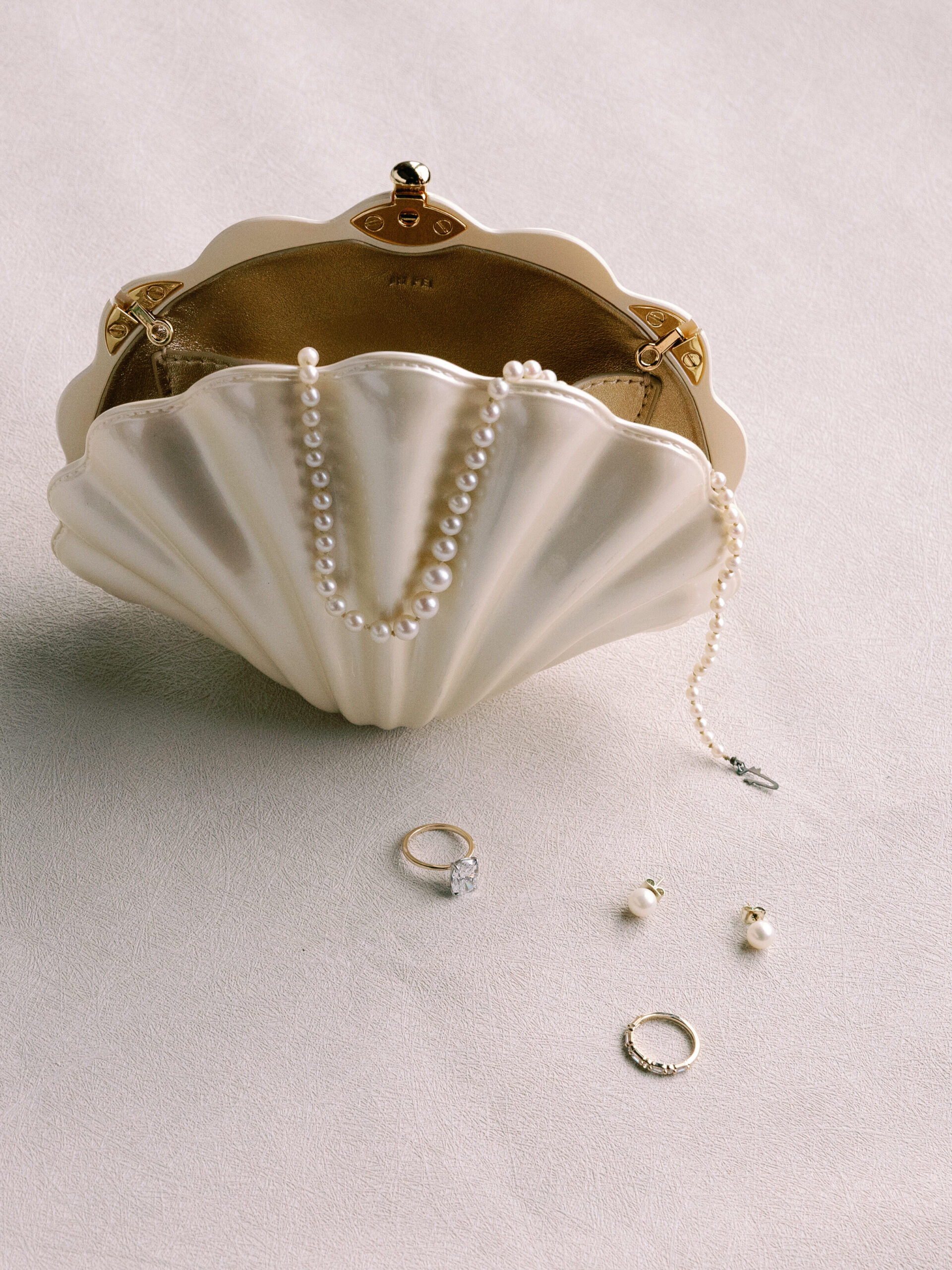 Close-up of antique jewelry honoring bride’s grandfather’s legacy in pearl clam clutch