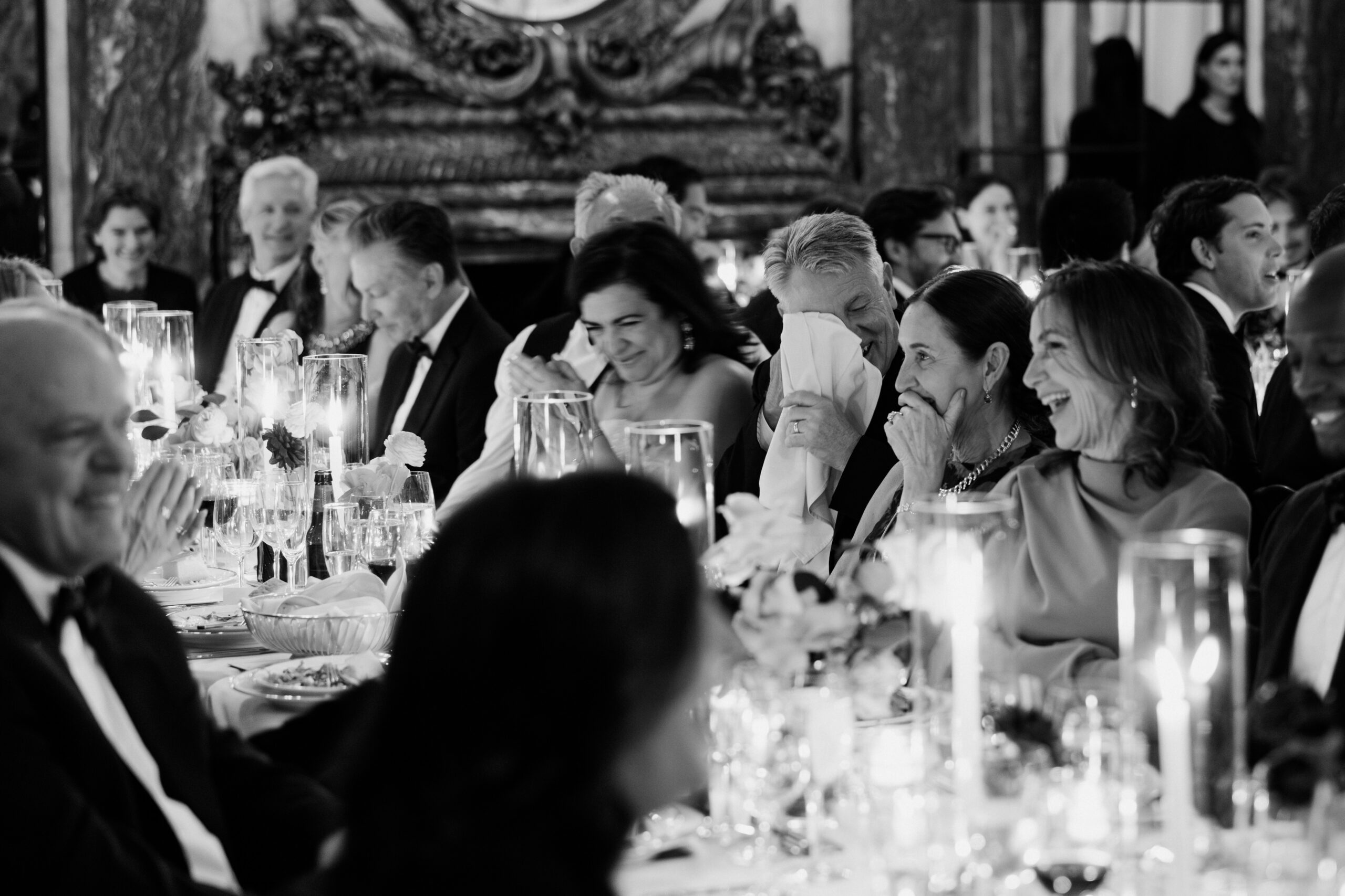 candid moments of guests seated at long tables in dim, romantic lighting