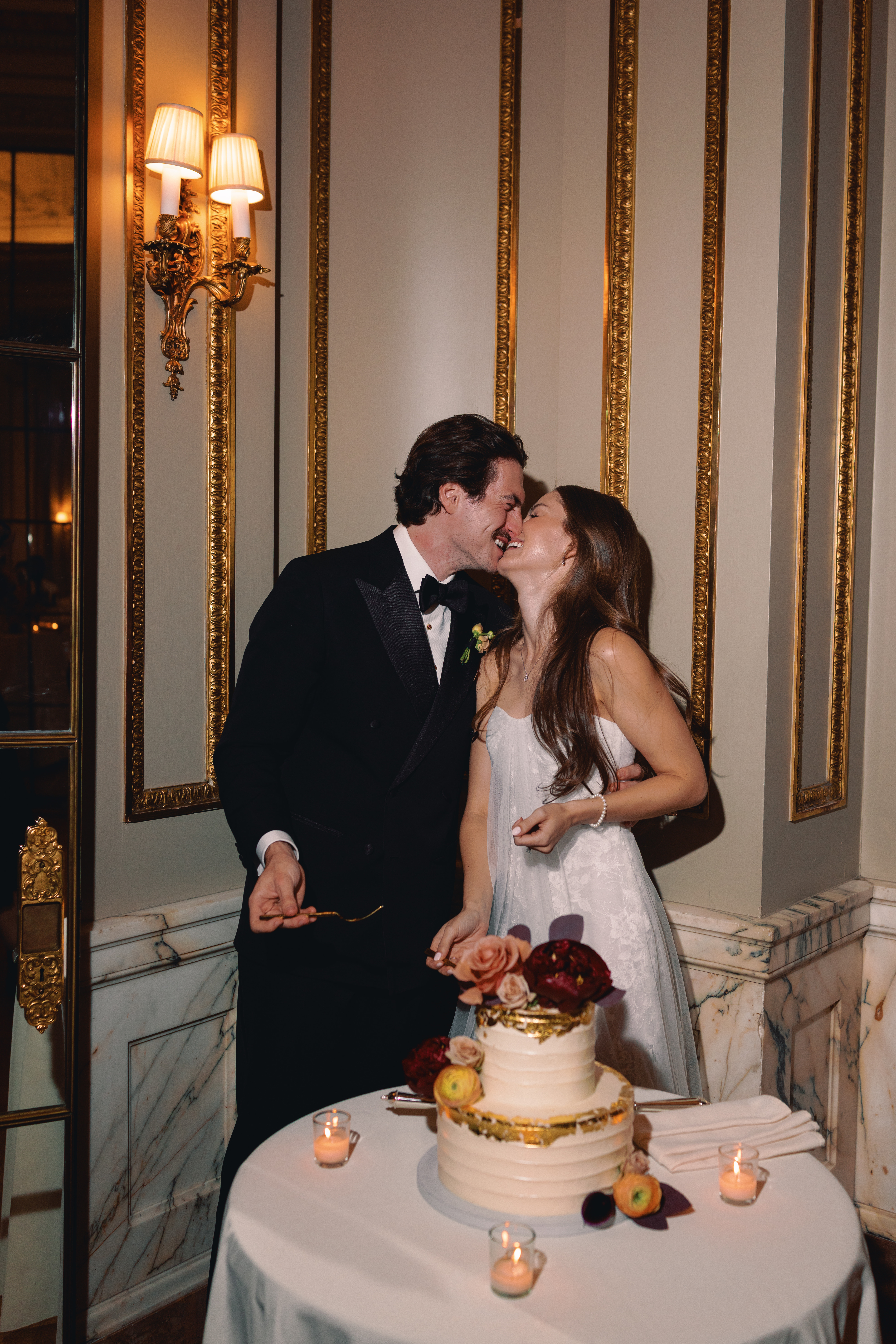 Bride and groom cutting the cake in elegant mansion in new york city