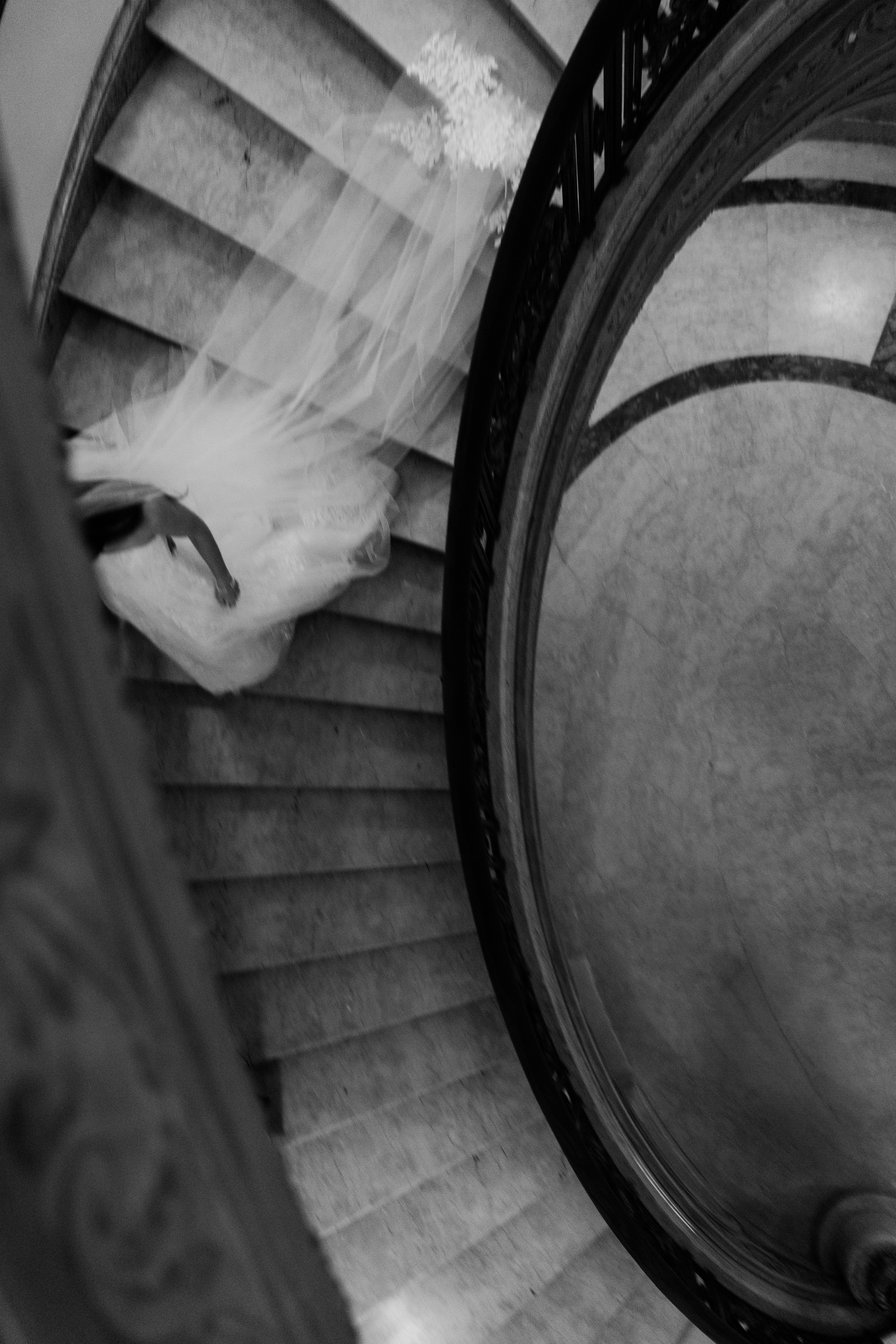 bride and groom on the winding staircase in Burden Kahn Mansion