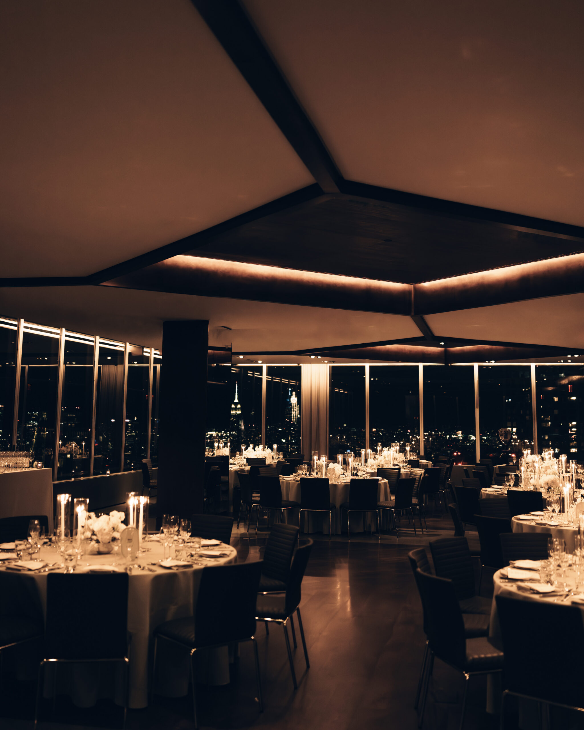 Candlelit reception space at Manhatta with skyline glowing at night