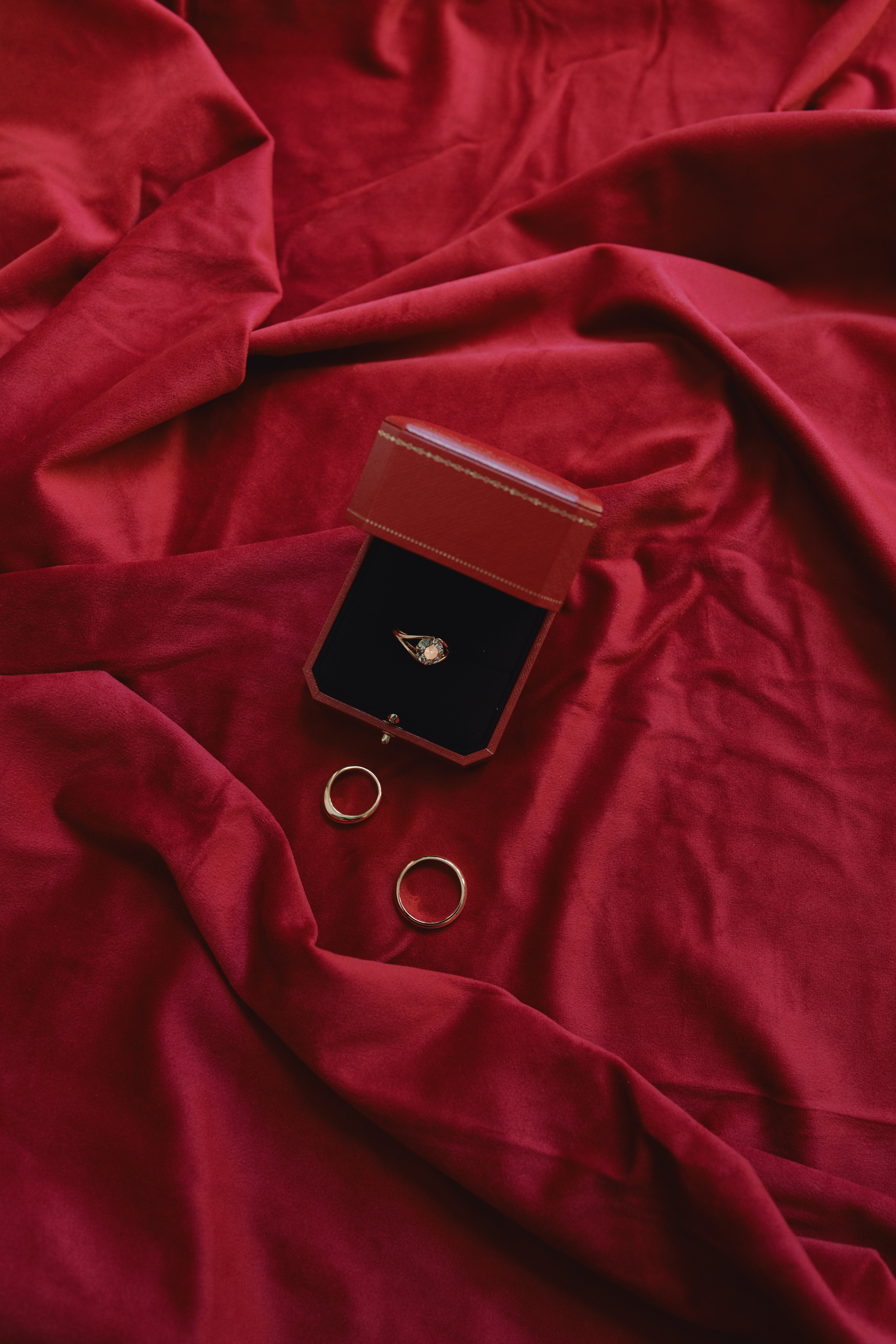 red wedding day detail photo of rings with silk linen 