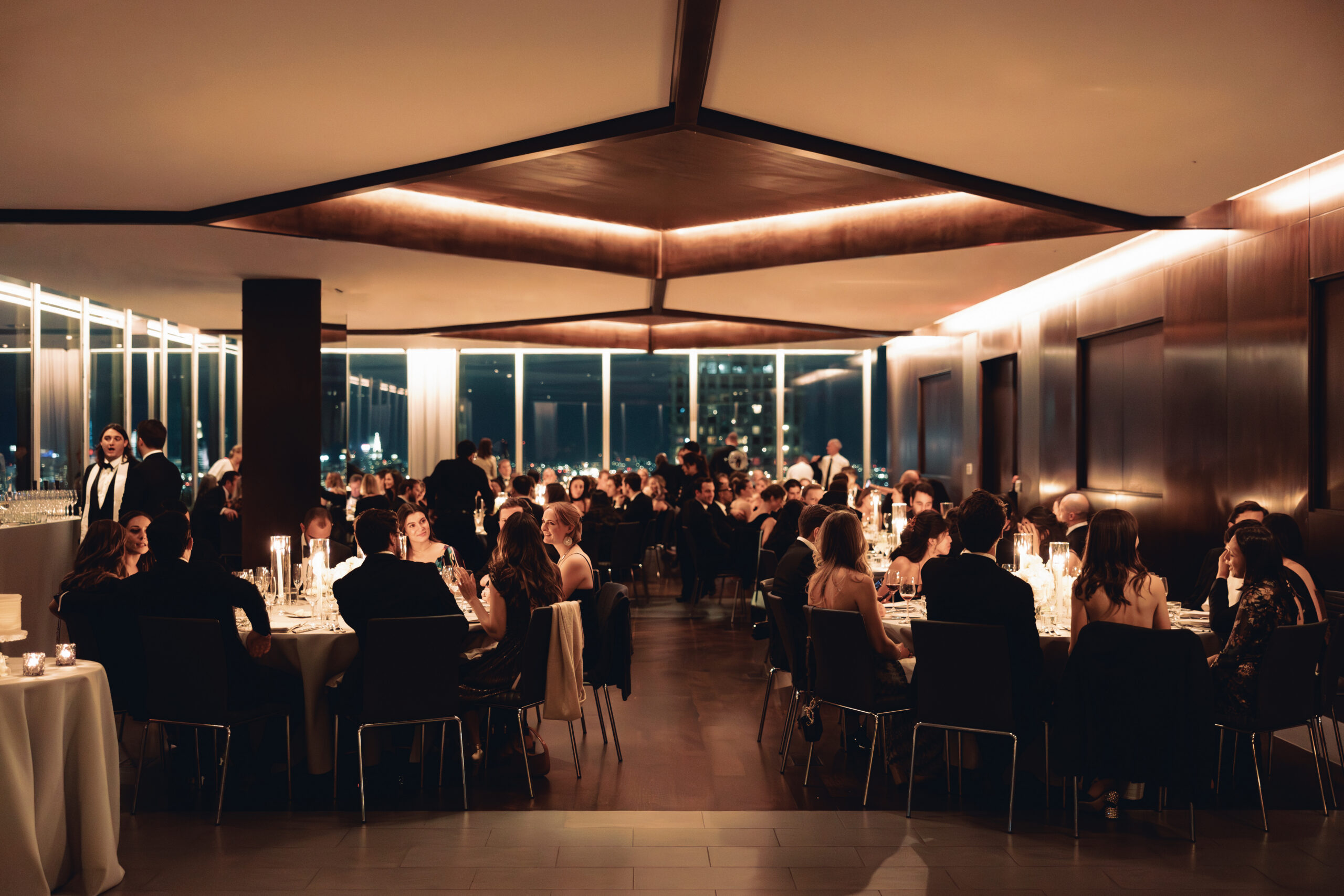 Candlelit reception space at Manhatta with skyline glowing at night
