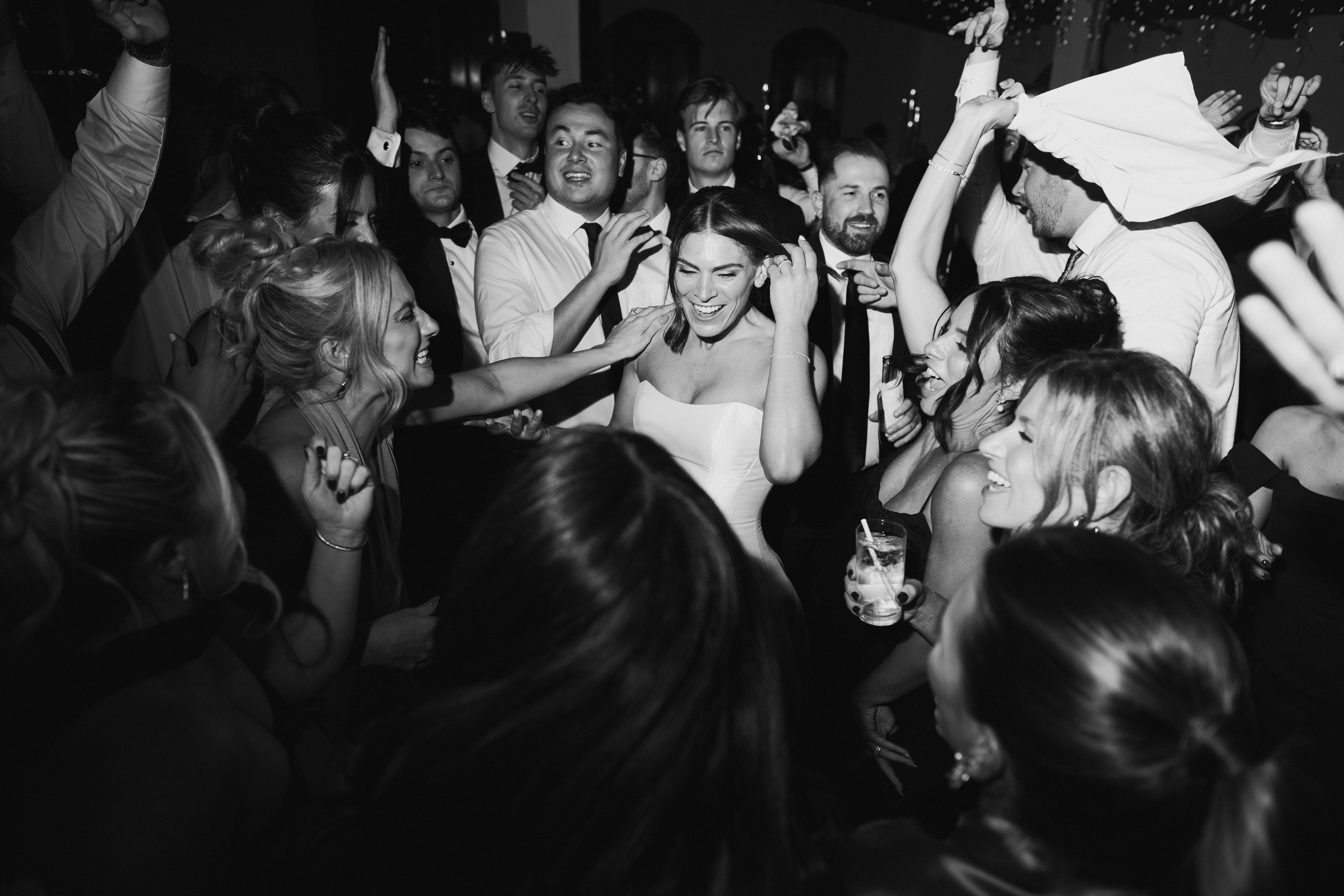 Black-and-white dance floor moment with guests mid-twirl, “all that jazz” energy