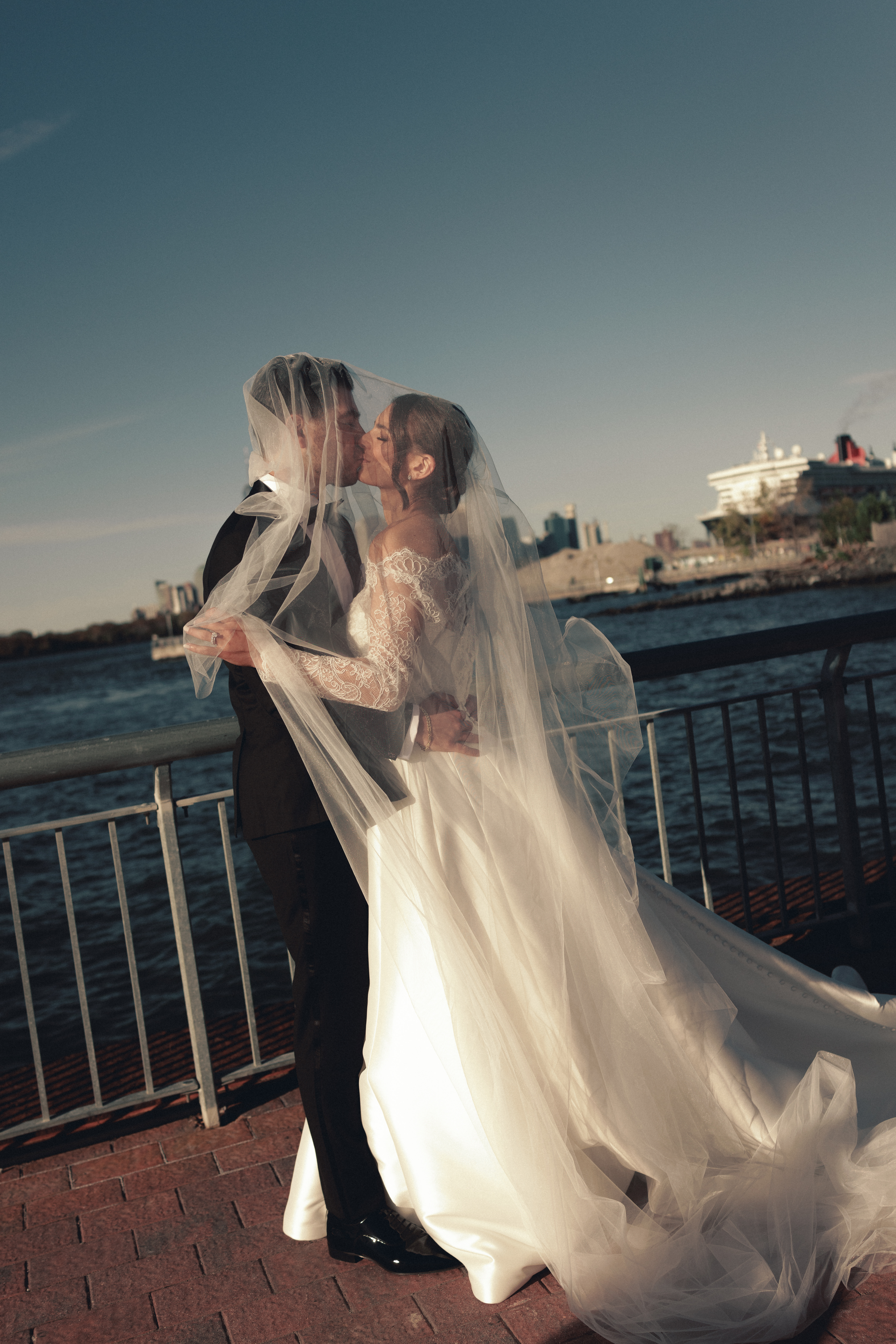 Emotional first look overlooking New York Harbor, non-face composition focused on hands and posture