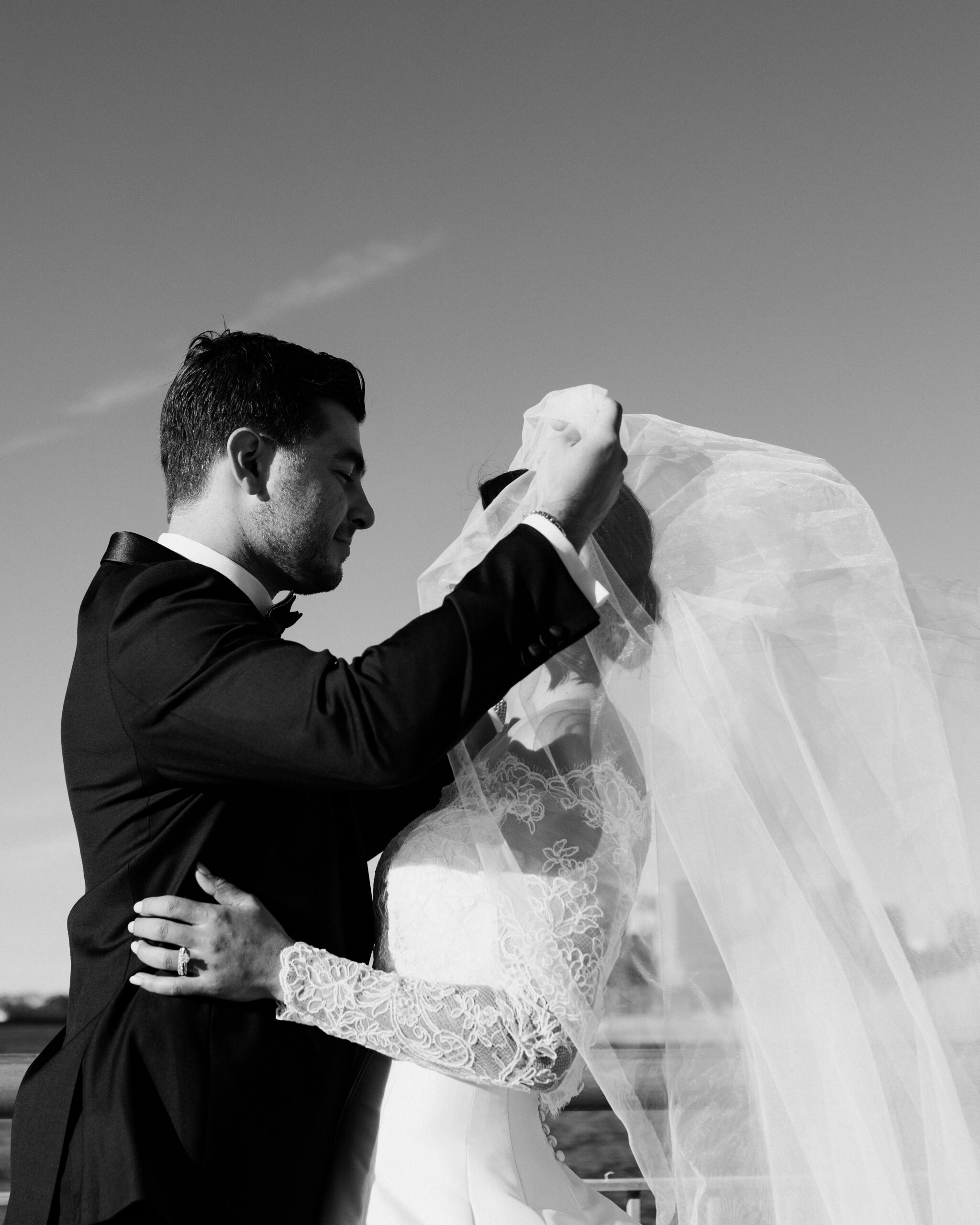 Emotional first look overlooking New York Harbor, non-face composition focused on hands and posture