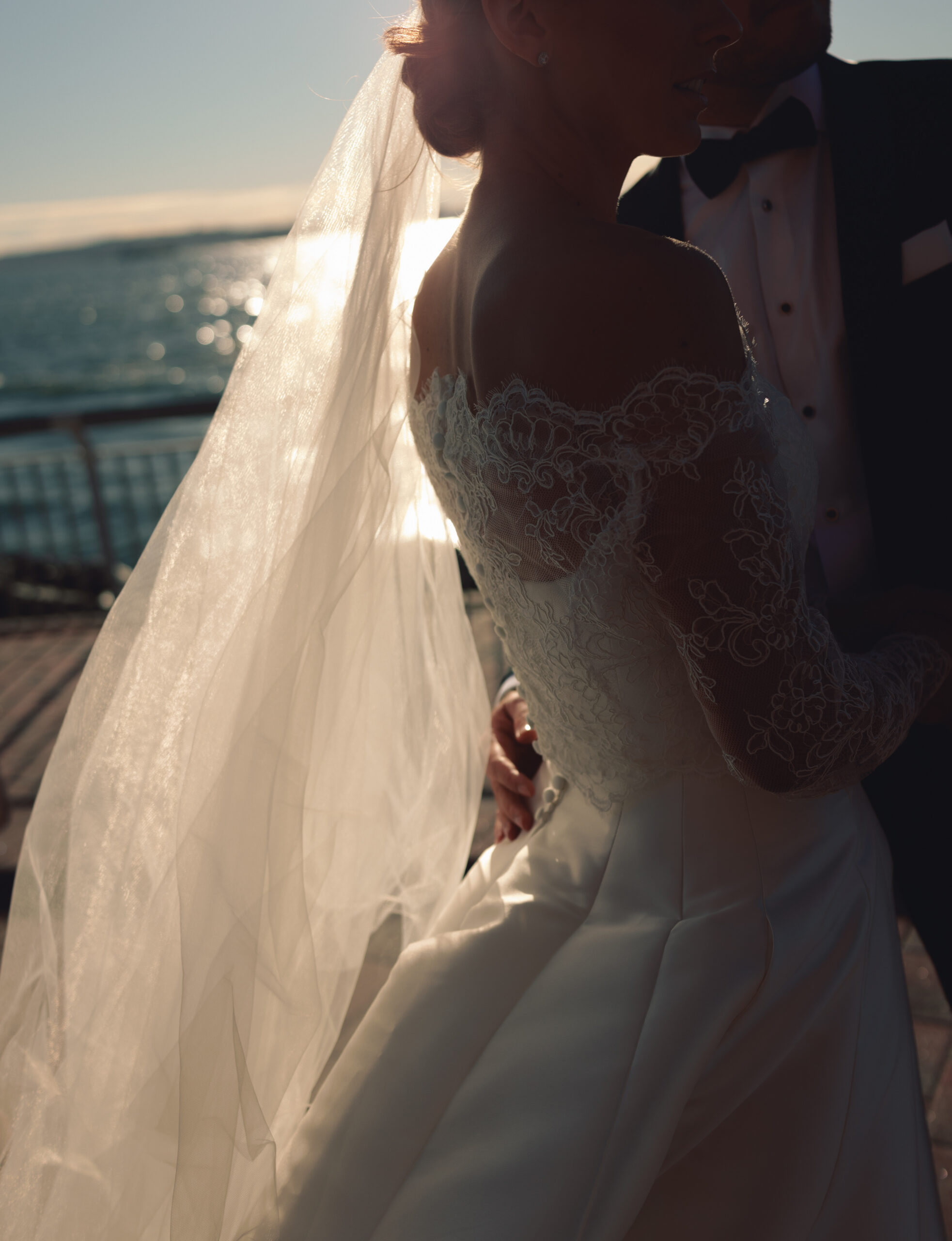 Emotional first look overlooking New York Harbor, non-face composition focused on hands and posture