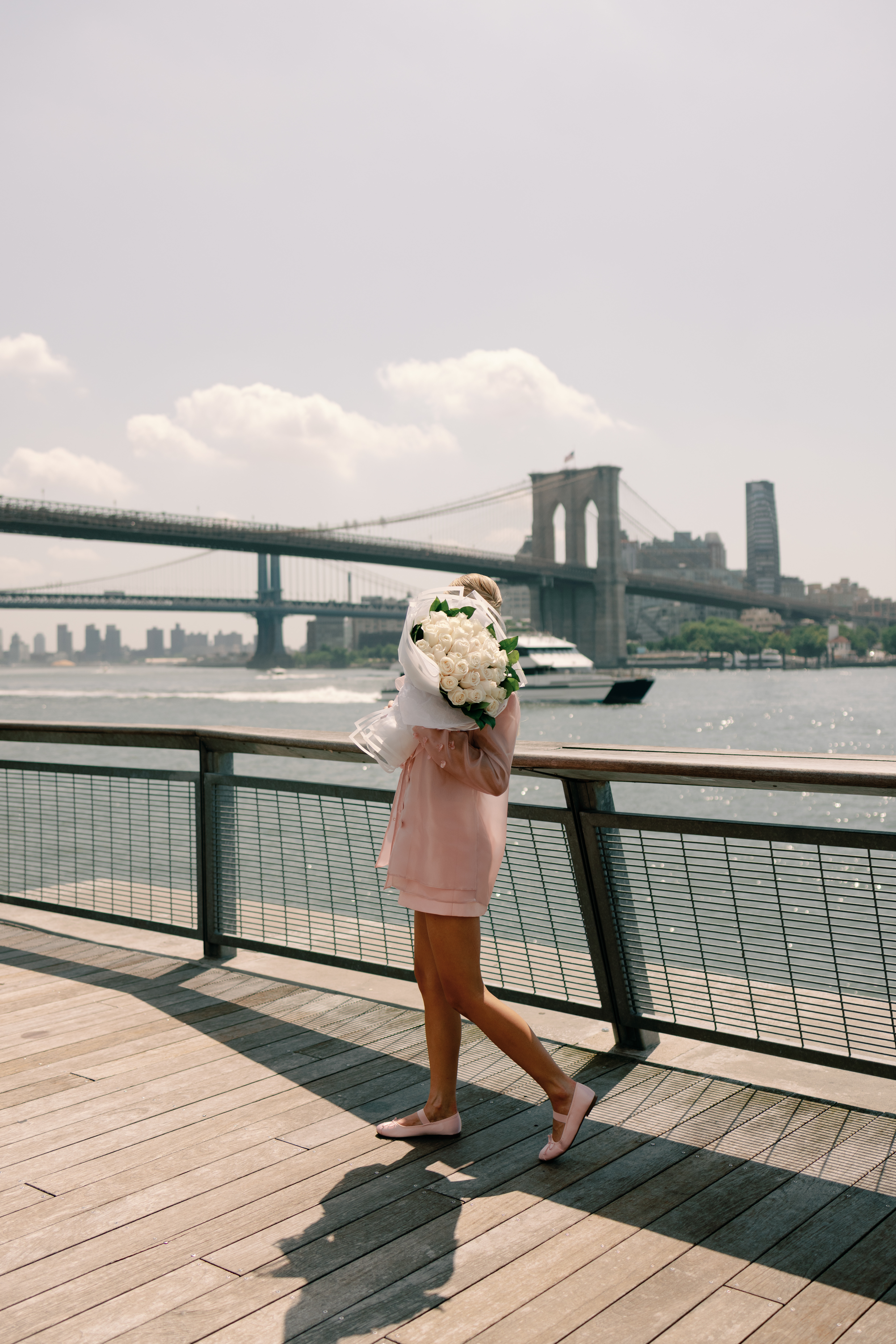 bride walking through Manhattan streets in candid engagement moment in pink